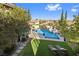 Aerial view of a backyard featuring a pool, a spa, and outdoor seating areas with lounge chairs at 320 Lorelei Rock St, Las Vegas, NV 89138