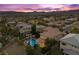 Breathtaking aerial view showcasing the expansive property, backyard pool, and neighborhood landscape at sunset at 320 Lorelei Rock St, Las Vegas, NV 89138