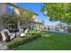 The backyard boasts a stunning pool area, lush greenery, and a comfortable outdoor seating area at 320 Lorelei Rock St, Las Vegas, NV 89138