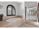 Bright bathroom features a soaking tub with tiled surround and arched window at 320 Lorelei Rock St, Las Vegas, NV 89138