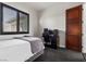 This bedroom includes a bed, a wooden door, and a computer desk setup for work or gaming at 320 Lorelei Rock St, Las Vegas, NV 89138