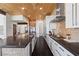 Bright kitchen featuring custom cabinets, modern appliances, black countertops, wood ceiling and sleek island design at 320 Lorelei Rock St, Las Vegas, NV 89138