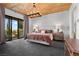 Bright main bedroom with wood ceiling, chandelier, and doors to an outdoor balcony at 320 Lorelei Rock St, Las Vegas, NV 89138