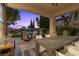 Covered patio area with a large dining table, chairs, and backyard views at 320 Lorelei Rock St, Las Vegas, NV 89138