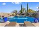 Beautiful backyard featuring a sparkling pool, hot tub, palm trees, and lounge chairs for relaxation at 320 Lorelei Rock St, Las Vegas, NV 89138