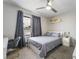 Comfortable bedroom featuring a bed, a desk, a window with gray curtains, carpet flooring and ceiling fan at 3221 Yolanda Ln, Las Vegas, NV 89121