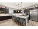 Modern kitchen featuring dark wood cabinets, stainless steel appliances, and a large center island at 352 Dandelion Brook Ct, Las Vegas, NV 89148