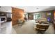 Bright living room with a brick accent wall and neutral-toned furnishings, seamlessly connecting to the dining area at 4592 Cabo Ln, Las Vegas, NV 89121