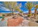 Beautiful backyard patio area featuring desert landscaping with mature trees at 4910 Marywood Ct, Pahrump, NV 89061
