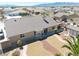 Aerial view of the back of the house with tan stucco, a tile roof, desert landscaping, and a small covered patio at 4910 Marywood Ct, Pahrump, NV 89061