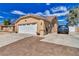 Side view of a home with a large driveway, two-car garage, and low-maintenance landscaping at 4910 Marywood Ct, Pahrump, NV 89061