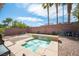Backyard view with a small jacuzzi-style spa with water feature and low-maintenance desert landscaping at 5615 Believe Ct, Las Vegas, NV 89139