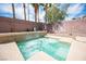 Inviting backyard with a tiled hot tub featuring a water feature surrounded by decorative brick and rock at 5615 Believe Ct, Las Vegas, NV 89139