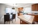 Bright kitchen features wood cabinets, island with tile countertops, and adjacent dining area at 5615 Believe Ct, Las Vegas, NV 89139