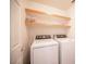 Efficient laundry area with modern, white washer and dryer set and open wood shelving at 5615 Believe Ct, Las Vegas, NV 89139