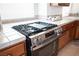 Close up of a stainless steel gas range and oven with tile countertops at 5615 Believe Ct, Las Vegas, NV 89139