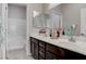 Bathroom featuring double sinks, wood-look floors, and tile walls at 6833 Wispy Sky Ct, Las Vegas, NV 89142