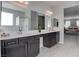 Bathroom with long double sink vanity, wood cabinets, and framed mirrors at 6833 Wispy Sky Ct, Las Vegas, NV 89142