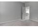 A bright and airy bedroom features neutral walls, carpet and an open doorway to another room at 6833 Wispy Sky Ct, Las Vegas, NV 89142