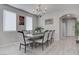 Dining room with a large table, modern chandelier, and bright natural light from the windows at 6833 Wispy Sky Ct, Las Vegas, NV 89142
