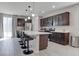 Well-appointed kitchen with a large island, stainless steel appliances, dark wood cabinets, and modern lighting at 6833 Wispy Sky Ct, Las Vegas, NV 89142