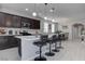 Beautiful kitchen featuring a large island with bar seating, modern appliances, and stylish dark wood cabinetry at 6833 Wispy Sky Ct, Las Vegas, NV 89142