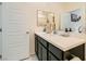Modern bathroom vanity with a white countertop, black cabinets, and a door leading to a separate area at 7308 N Decatur Blvd # 1, Las Vegas, NV 89131