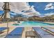 Stunning community pool area with lounge chairs, umbrella and well-maintained landscaping at 7308 N Decatur Blvd # 1, Las Vegas, NV 89131