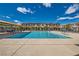 Relaxing community pool surrounded by lounge chairs and umbrellas under a bright blue sky at 7308 N Decatur Blvd # 1, Las Vegas, NV 89131