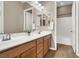 Bathroom featuring double sinks with wood cabinets, a large mirror, and a separate tub/shower area at 7420 Zonal Ave, Las Vegas, NV 89131
