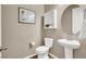 Well-lit half bath featuring a pedestal sink, decorative mirror, and neutral tones for a clean aesthetic at 7420 Zonal Ave, Las Vegas, NV 89131
