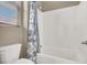 Bright bathroom featuring a tub/shower combination with white tile and a blue and white shower curtain at 7420 Zonal Ave, Las Vegas, NV 89131