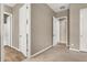 Hallway with neutral walls, carpet, wood-look floors, and multiple doorways leading to various rooms at 7420 Zonal Ave, Las Vegas, NV 89131