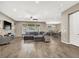 Open-concept living area with a large sectional sofa, wood flooring, and a view of the dining area at 7420 Zonal Ave, Las Vegas, NV 89131