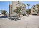 Corner view of condo building and parking area with desert landscaping and palm trees at 745 N Royal Crest Cir # 158, Las Vegas, NV 89169