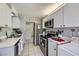 Galley kitchen featuring white cabinets, stainless steel appliances, and marble countertops at 745 N Royal Crest Cir # 158, Las Vegas, NV 89169