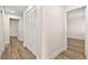 Hallway with fresh paint, wood floors, doors to rooms and a large closet with louvered doors at 7554 Violet Vista Ave # 201, Las Vegas, NV 89130