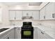 Well-lit kitchen with white cabinets, black hardware, modern countertops and stainless steel appliances at 7554 Violet Vista Ave # 201, Las Vegas, NV 89130