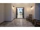 Welcoming entryway featuring tile flooring, neutral walls, sconce lighting, and outdoor seating area with rocking chairs at 8000 Clock Tower Ct, Las Vegas, NV 89117