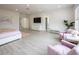 Bright main bedroom with light colored wood floors, light pink bedding, and a seating area at 8000 Clock Tower Ct, Las Vegas, NV 89117