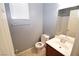 Simple half bathroom with a white toilet, sink, and a mirror over the sink at 8084 Bosco Bay Ave, Las Vegas, NV 89113