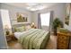 Charming bedroom features a green bed frame and a light-filled window at 8084 Bosco Bay Ave, Las Vegas, NV 89113