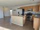 Traditional kitchen features an island, stainless steel appliances, and tile floors at 8993 Secret Valley St, Las Vegas, NV 89139
