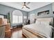 Well-lit bedroom with hardwood floors, ceiling fan, and large window at 9225 Evergreen Canyon Dr, Las Vegas, NV 89134
