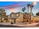 Two-story home featuring a two-car garage and desert landscaping with palm trees on a corner lot at 9225 Evergreen Canyon Dr, Las Vegas, NV 89134