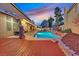 Backyard pool with a wooden deck and rock details at sunset at 9225 Evergreen Canyon Dr, Las Vegas, NV 89134