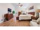 Bright primary bedroom showcasing a wood floor, ceiling fan, and large windows for natural light and comfort at 9356 Column Cactus St, Las Vegas, NV 89139