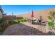 Relaxing backyard featuring a stone patio with seating, artificial grass, and a charming desert landscape at 984 Brilliant Meadow Ave, North Las Vegas, NV 89086