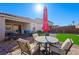 Inviting backyard featuring artificial grass, a patio area with a table and chairs, and low-maintenance landscaping at 984 Brilliant Meadow Ave, North Las Vegas, NV 89086