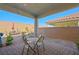 Charming covered patio with a brick paver floor, comfortable seating, and desert landscaping views at 984 Brilliant Meadow Ave, North Las Vegas, NV 89086